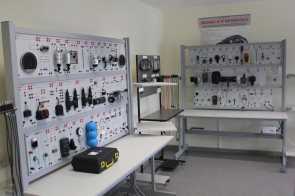 Stanowiska dydaktyczne z panelami zawierającymi elementy układów elektrycznych i elektronicznych; na stołach narzędzia i urządzenia pomiarowe - sala w ZSTiO w Skoczowie.