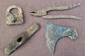 Kłódka, kleszcze, młotek i siekierka znalezione w obrębie piwnic