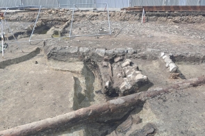 Obiekty drewniano-kamienne związane najprawdopodobniej z ciekiem wodnym płynącym przez plac. Na pierwszym planie drewniana rura wodociągowa ułożona w kierunku wylotu ul. Menniczej