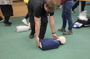 uczestnik szkolenia kładzie na ziemi fantom niemowlęcia