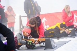 mała dziewczynka z karabinkiem sportowym, leżąca na śniegu