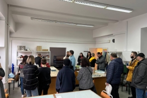 grupa uczestników zwiedzania w pracowni witrażu, słuchają panią Marynę Podolską