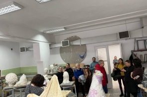 grupa uczestników zwiedzania w pracowni rzeźby, słuchają panią Marynę Podolską