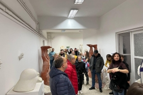 grupa uczestników zwiedzania w korytarzu Instytutu Sztuki, oglądają rzeźby