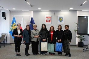 Laureatki olimpiady trzymają w ręce torby z nagrodami. Z lewej strony laureatek stoi ubrana na czarno Janina Żagan; z prawej strony laureatek stoi elegancko ubrane Jury: Marta Jonderko, Magdalena Wałach oraz Beata Macura. 