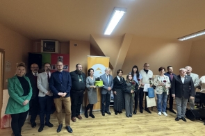 W Gminnym Ośrodku Kultury w Łączce uczestnicy konkursu „Selfie z marką Śląsk Cieszyński” stoją razem podczas uroczystego podsumowania i wręczenia nagród. W tle baner akcji, nagrodzeni trzymają dyplomy i róże, panuje radosna, oficjalna atmosfera.