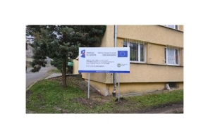 Budynek internatu przy Zespole Szkół imienia Władysława Szybińskiego w Cieszynie, przed którym stoi tablica informacyjna o dofinansowaniu przez Unię Europejską