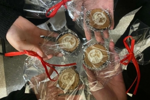 Osoby siedzą na krzesłach i słuchają wystąpienia. Z przodu stoi kobieta z mikrofonem. Na ekranie wyświetlona jest prezentacja z Władysławem Reymontem. 