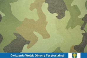 Na tle wzoru moro w odcieniach zieleni, brązu i czerni widnieje niebieski pasek, w którym umieszczono biały napis informacyjny oraz herb Powiatu Cieszyńskiego. Kompozycja nawiązuje do tematyki wojskowej.