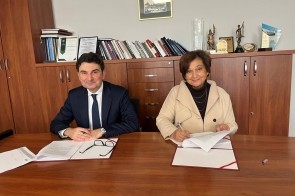 Wojewoda Śląski Marek Wójcik i Janina Żagan Starosta Cieszyński podpisują umowę przy stole w gabinecie starosty.