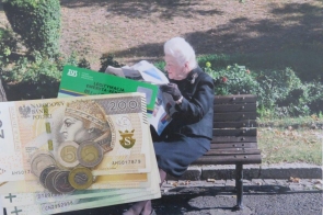 Starsza pani siedząca na ławce w parku, trzymająca gazetę , z widocznym w tle zielenią, a na pierwszym planie banknot 200 złotych, monety oraz legitymacja emeryta-rencisty.