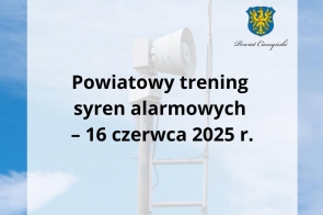 Widoczna syrena alarmowa ustawiona na tle nieba z lekkimi chmurami. Na półprzezroczystym tle umieszczono napis: „Powiatowy trening syren alarmowych – 16 czerwca 2025 r.” oraz herb Powiatu Cieszyńskiego.