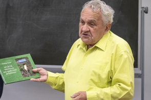 Na zdjęciu jest Władysław Kristen ubrany w żółtą koszulę . W ręku trzyma jubileuszową publikację „25-lecie spotkań przy źródle Olzy na Gańczorce”. W tle widać tablicę – zdjęcie zostało wykonane w Polskim Gimnazjum im. Juliusza Słowackiego w Czeskim Cieszynie.