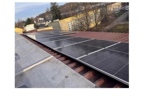 Instalacja fotowoltaiczna na dachu internatu przy Zespole Szkół imienia Władysława Szybińskiego w Cieszynie. W oddali widać budynki mieszkalne.