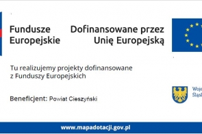 Na jasnym tle znajdują się logotyp Funduszy Europejskich w kolorach niebieskim, żółtym i czerwonym oraz flaga Unii Europejskiej w kolorze niebieskim z żółtymi gwiazdami. Widoczna jest informacja o dofinansowaniu przez Unię Europejską, nazwie beneficjenta – Powiat Cieszyński – oraz herb Województwa Śląskiego. Na dole wskazany jest adres strony internetowej.