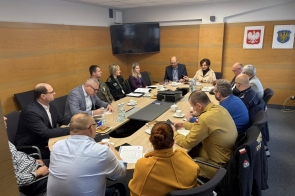 Spotkanie służb. PRzy stole siedzą uczestnicyspotkania wraz z Janiną Żagan Starostą Cieszyńską