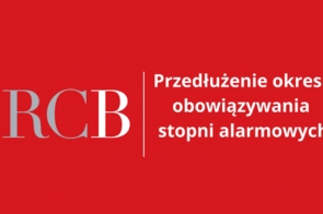 Grafika w czerwonym tle z dużym, szarym skrótem literowym "RCB" po lewej stronie. Po prawej stronie biały napis informacyjny w kilku liniach dotyczący przedłużenia okresu alarmowego.