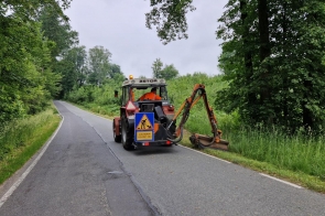 Koszenie poboczy przy drodze powiatowej przez traktor - zdjęcie wyróżniające