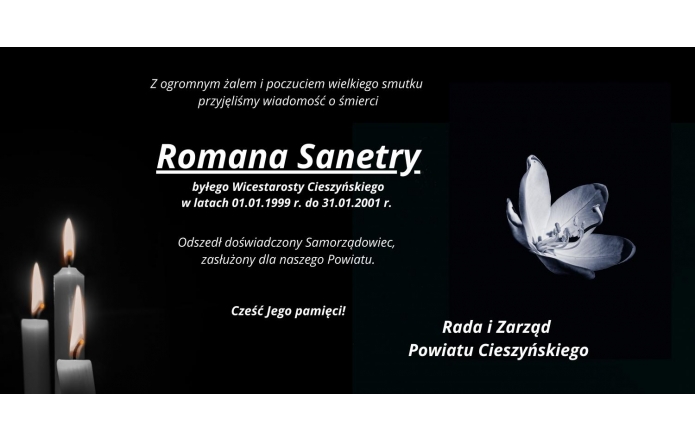 Plansza kondolencyjna z informacją o śmierci Romana Sanetry, byłego wicestarosty Powiatu Cieszyńskiego. Po lewej stronie widoczne zapalone świece, po prawej biały kwiat na ciemnym tle. Na dole podpis: Rada i Zarząd Powiatu Cieszyńskiego.