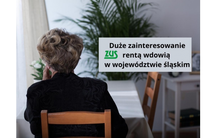 Starsza kobieta siedzi przy stole, odwrócona tyłem, z ręką opartą o policzek. Ubrana na czarno, patrzy przez okno w jasnym, domowym wnętrzu. Obok widnieje komunikat o dużym zainteresowaniu rentą wdowią z ZUS w województwie śląskim.
