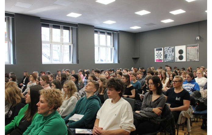 Młodzież i nauczyciele zasłuchani podczas konferencji w Sali konferencyjnej UŚ w Cieszynie. Pełne skupienia twarze, w tle nowoczesne wnętrze z dużymi oknami i plakatami na ścianie. Edukacyjne wydarzenie przyciągnęło liczne grono uczestników.