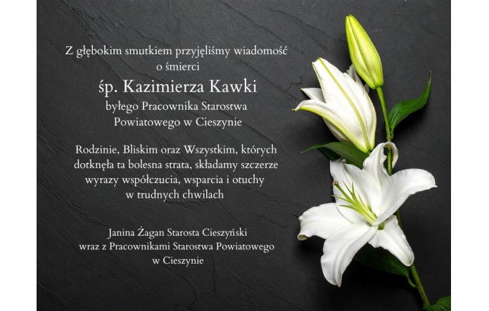 Czarny kamienny blat z dwiema białymi liliami po prawej stronie. Po lewej stronie umieszczony tekst z wyrazami współczucia po śmierci śp. Kazimierza Kawki, byłego pracownika Starostwa Powiatowego w Cieszynie,  zakończony informacją, że kondolencje składa Janina Żagan, Starosta Cieszyński, wraz z pracownikami Starostwa.
