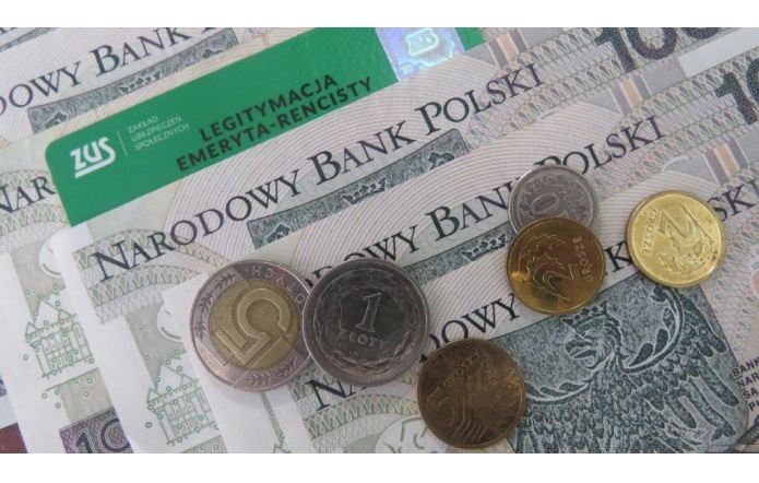 Polskie banknoty i monety różnych nominałów ułożone pod zieloną legitymacją emeryta-rencisty ZUS. W tle widoczny napis „Narodowy Bank Polski” na banknotach stuzłotowych.