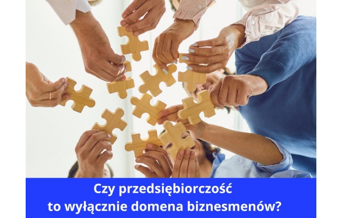 Kilka osób wspólnie układa drewniane puzzle, trzymając je nad głowami w geście współpracy. Obraz sugeruje działanie zespołowe i wspólne poszukiwanie rozwiązań. W dolnej części grafiki znajduje się niebieski pasek z białym napisem: „Czy przedsiębiorczość to wyłącznie domena biznesmenów?”. Całość budzi refleksję nad szerszym znaczeniem przedsiębiorczości.