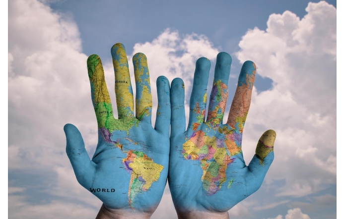 Ręce, na których narysowana mapa świata