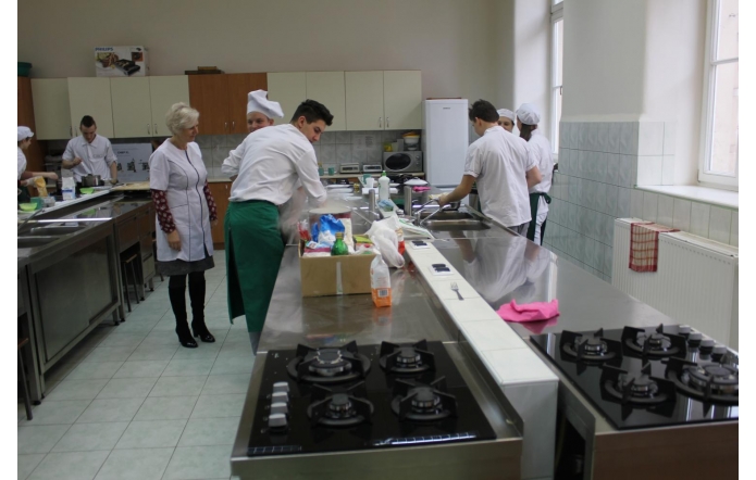 Pracownia technologii gastronomicznej – uczniowie w profesjonalnej kuchni przygotowują dania pod okiem nauczyciela. Nowoczesne wyposażenie, kuchenki gazowe i stanowiska pracy umożliwiają zdobywanie praktycznych umiejętności zawodowych.